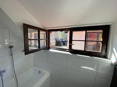 a bathroom with a window and a bath tub at Penzion U Adama in Karlštejn