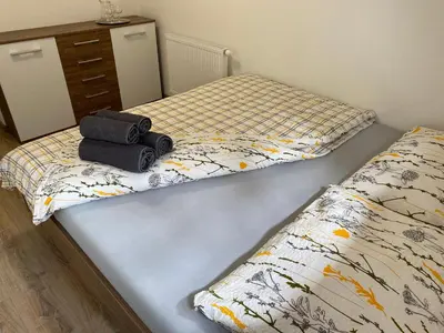 a bedroom with a bed with a suitcase on it at Penzion U Adama in Karlštejn