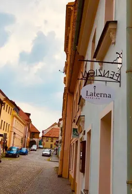 a bedroom with a bed and a desk and a window at Penzion Laterna in Litoměřice