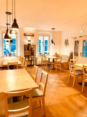 a restaurant with wooden tables and chairs and windows at Penzion Laterna in Litoměřice