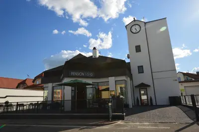 a building with a clock tower in front of it at Pension 1310 in Mladá Boleslav
