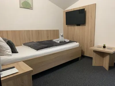a bedroom with a bed and a flat screen tv at Pension 1310 in Mladá Boleslav