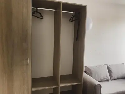 a wooden cabinet with two lights on it next to a bed at Pension 1310 in Mladá Boleslav