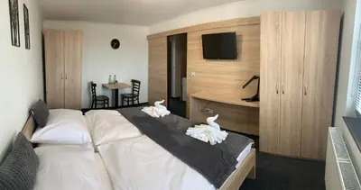 a hotel room with a large bed and a desk at Pension 1310 in Mladá Boleslav
