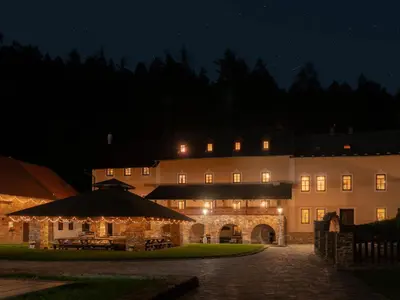 a large building with lights in front of it at night at Mlýn Davídkov in Hryzely