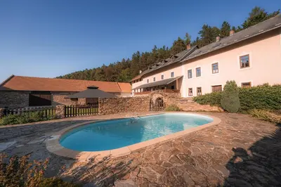 a swimming pool in a yard next to a building at Mlýn Davídkov in Hryzely