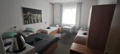 a room with two beds and a desk and a window at Orbis in Prague