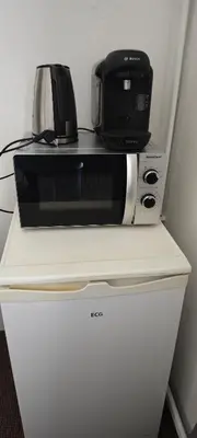 a microwave sitting on top of a refrigerator at Orbis in Prague