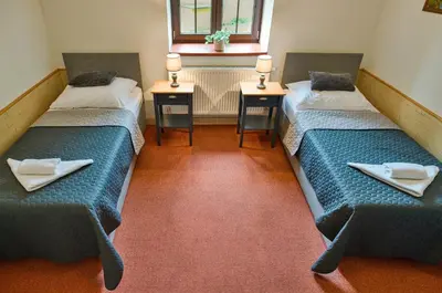 a room with two beds and two tables with napkins on them at Hotel U Lípy in Krušovice