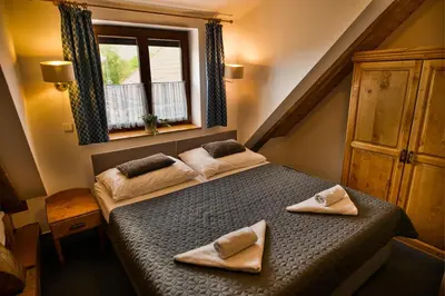 a bedroom with a bed with two towels on it at Hotel U Lípy in Krušovice