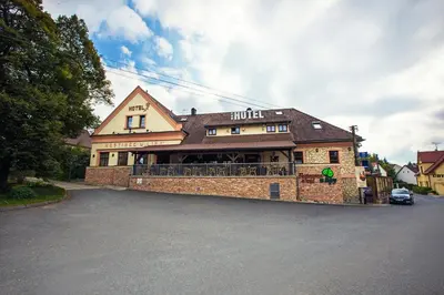 a building with a car parked in front of it at Hotel U Lípy in Krušovice