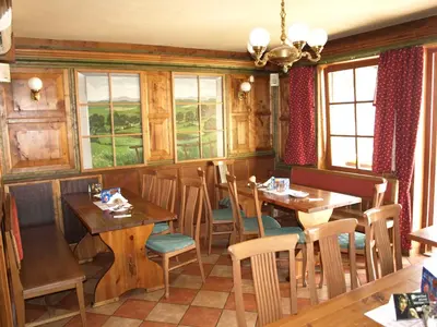 a restaurant with wooden tables and chairs and windows at Hotel U Lípy in Krušovice