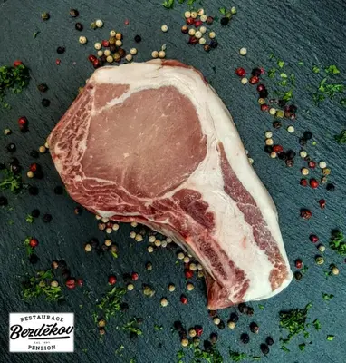a piece of meat on a table with other ingredients at Penzion Bezděkov in Rakovník