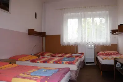 a room with three beds and a window at Penzion Bezděkov in Rakovník