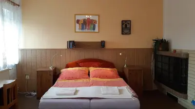 a bedroom with a bed with a red head board at Penzion Bezděkov in Rakovník