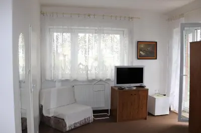 a living room with a tv and a chair and a window at Penzion Bezděkov in Rakovník
