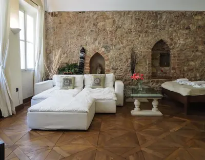 a living room with white couches and a brick wall at Karlova - Old Town Apartment in Prague