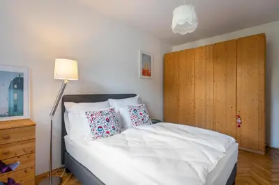 a bedroom with a white bed with a wooden headboard at *SUNNY and STYLISH* Apt with BALCONY near TV Tower in Prague