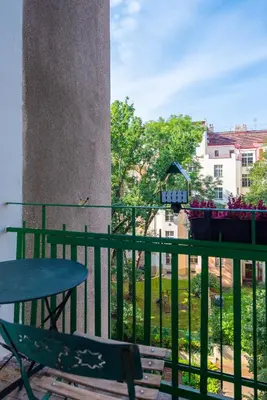 a table and a chair on a balcony at *SUNNY and STYLISH* Apt with BALCONY near TV Tower in Prague
