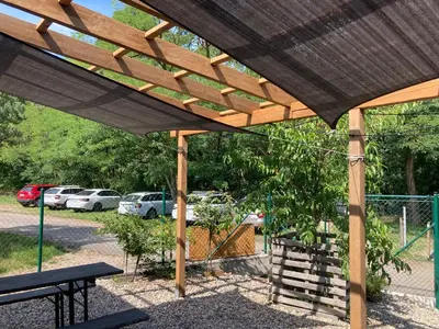 a wooden pavilion with a picnic table and a parking lot at KuK Račice in Račice
