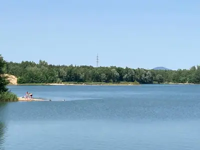 a large body of water with people on the shore at KuK Račice in Račice