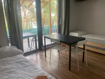 a room with a table and chairs and a balcony at KuK Račice - pokoj s malou terasou in Račice