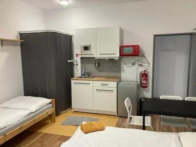 a small kitchen with white cabinets and a refrigerator at KuK Račice - pokoj s malou terasou in Račice
