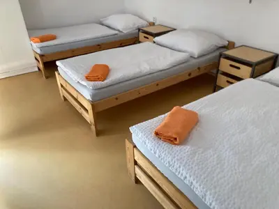 a room with three beds with orange towels on them at KuK Račice - 4 loznice in Račice
