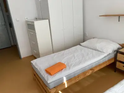 a small bedroom with a bed with an orange towel on it at KuK Račice - 4 loznice in Račice