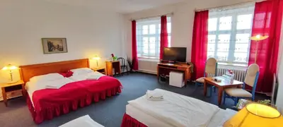 a hotel room with two beds and a television at Hotel Magnolia in Roudnice nad Labem