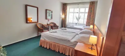 a room with two beds and a mirror at Hotel Magnolia in Roudnice nad Labem