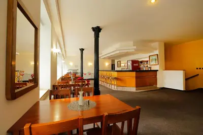 a dining room with a table and chairs and a kitchen at Hotel Magnolia in Roudnice nad Labem