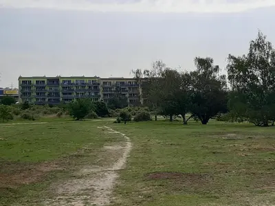 a building in a field with a dirt road at Apartment Park Radouč - 60m2 in Mladá Boleslav