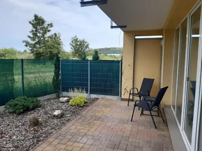 a patio with two chairs and a fence at Apartment Park Radouč - 60m2 in Mladá Boleslav