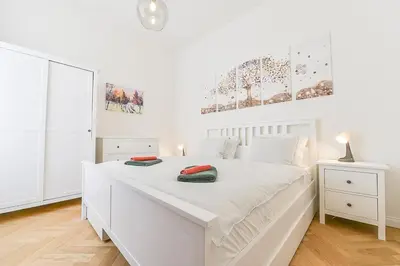 a white bedroom with a white bed with two pillows on it at Brand New Apartment next to Old Town Square in Prague