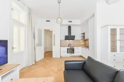 a living room with a couch and a kitchen at Brand New Apartment next to Old Town Square in Prague