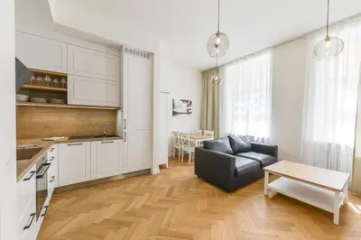 a kitchen and a living room with a couch and a table at Brand New Apartment next to Old Town Square in Prague