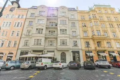 a large building with cars parked in front of it at Brand New Apartment next to Old Town Square in Prague