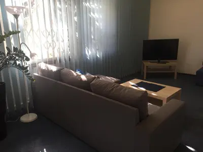 a living room with a couch and a television at Blue apartment in beautiful English style garden with atmosphere in Prague