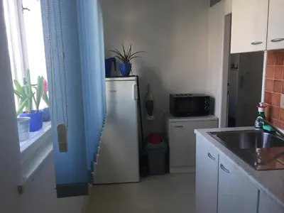 a small kitchen with a refrigerator and a sink at Blue apartment in beautiful English style garden with atmosphere in Prague