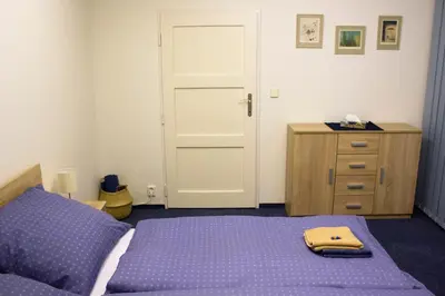 a bedroom with a purple bed and a dresser at Blue apartment in beautiful English style garden with atmosphere in Prague
