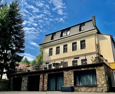an old brick building with a tree in front of it at Penzion Kokorin Forest Villa in Konrádov