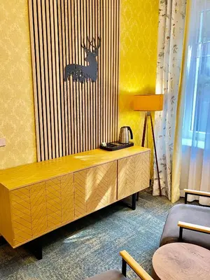 a room with a wooden cabinet with a deer on the wall at Penzion Kokorin Forest Villa in Konrádov