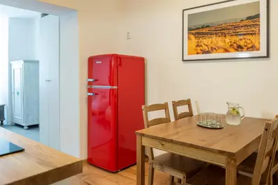 a red refrigerator in a dining room with a table at Dobrý Kanec - Hostinec in Mělník