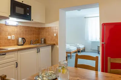 a kitchen with a table and a red refrigerator at Dobrý Kanec - Hostinec in Mělník