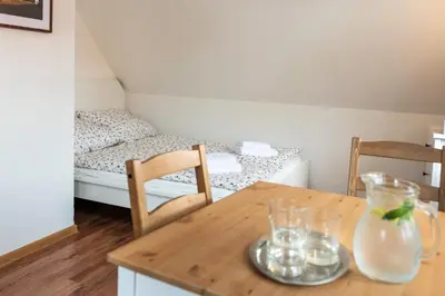 a wooden table with two chairs and a bed at Dobrý Kanec - Hostinec in Mělník