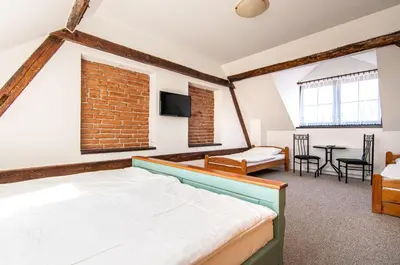 a bedroom with a bed and a living room at Penzion Zlaté Slunce in Chocenice
