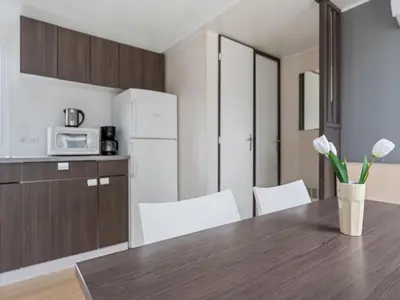 a kitchen with a wooden table and white chairs at Holiday Home Prima Plus by Interhome in Prague