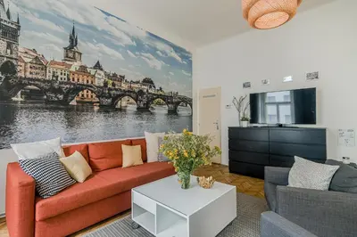a living room with a couch and a painting of a bridge at APT in center Prague by Michal&Friends in Prague
