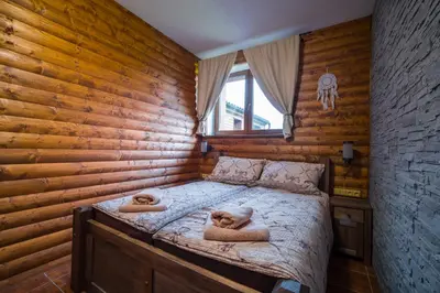 a bed in a wooden room with two dogs laying on it at Ranch Jestřebice in Heřmaničky